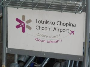 Logo auf einem Gepäckwagen am Flughafen Warschau-Chopin (Foto: Jan Gruber).