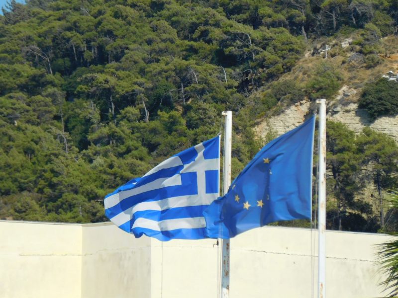 Flaggen der EU und Griechenlands vor dem Flughafen Rhodos (Foto: Jan Gruber).