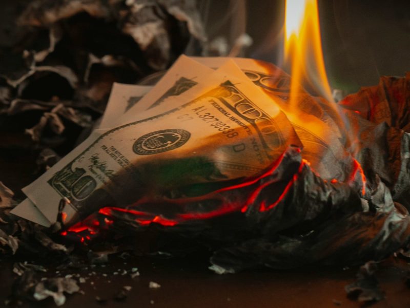 Burning money (Photo: p Valery/Unsplash).